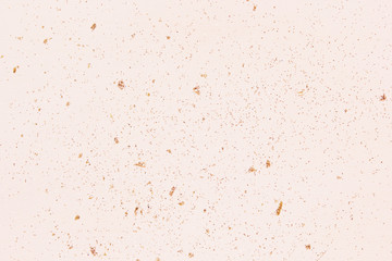 Pink champagne color glitter on light wood. Holiday celebration background. Close up, copy space