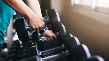 Crédence de cuisine en verre imprimé Fitness mains d& 39 homme soulevant des haltères sur un rack dans une salle de sport ou de fitness