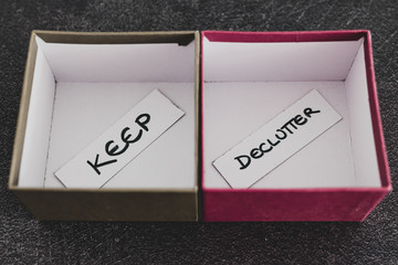  tidying up conceptual still-life, storage boxes with Keep and Declutter labels on them next to...