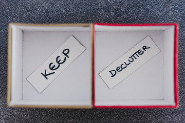  tidying up conceptual still-life, storage boxes with Keep and Declutter labels on them next to...