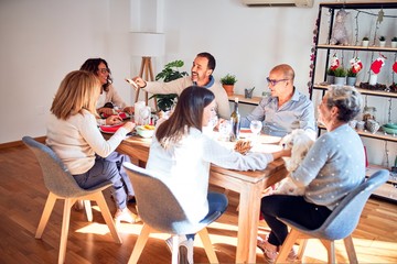 Family and friends dining at home celebrating christmas eve with traditional food and decoration, celebration of festive winter time