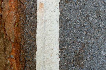 Old white line on asphalt road.