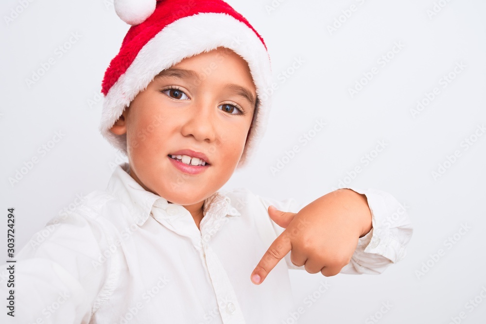 Sticker beautiful kid boy wearing christmas santa hat make selfie over isolated white background with surpri