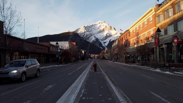 Downtown Banff, Alberta sits beneath Cascade Mountain at dusk