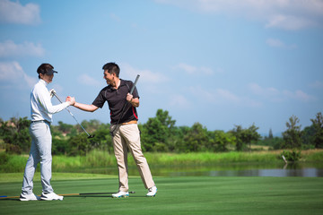 Two male golf players on professional golf course. Smiling golfers with golf clubs