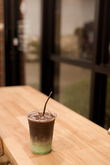 iced mint chocolate drink in plastic glass, put on a wooden table