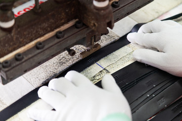 Craftsman using emboss machine with leather