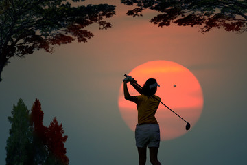 silhouette of woman golf player in action at the end of downswing hit a golf ball to destination in the fairway, best concentrate to destination of life CONCEPT