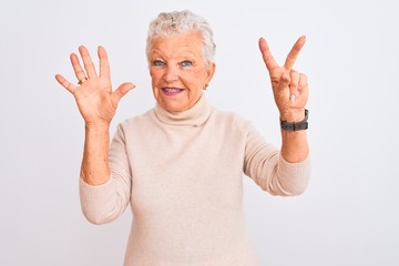 Senior grey-haired woman wearing turtleneck sweater standing over isolated white background showing and pointing up with fingers number seven while smiling confident and happy.