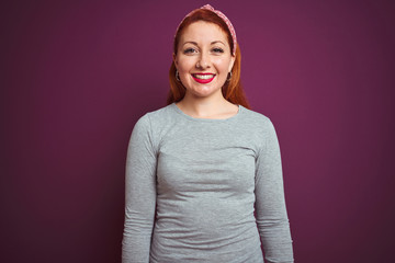 Obraz premium Beautiful redhead woman wearing grey t-shirt and diadem over isolated purple background with a happy and cool smile on face. Lucky person.