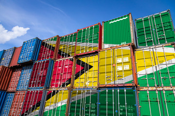 The national flag of Guyana on a large number of metal containers for storing goods stacked in rows...