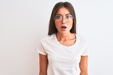 Young beautiful woman wearing casual t-shirt and glasses over isolated white background afraid and shocked with surprise expression, fear and excited face.