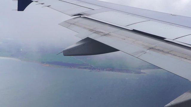 Aerial view before landing at Copehagen internation airport ocean and landscape cloudy sky