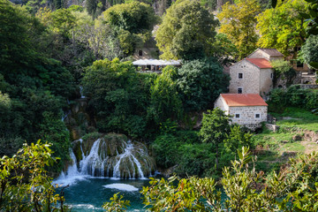 Fototapeta na wymiar View of waterfalls, lakes, and old mill buildings in Krka National Park, Croatia