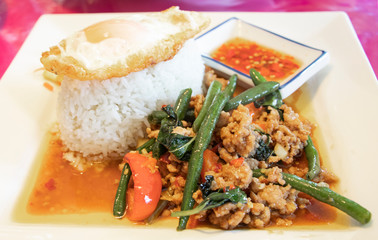 Stir fried ground pork with chilli, bail and vegetable severed with rice, fried egg and chilli fish sauce. Thai well known dish around the world