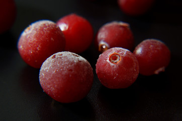 Frozen cranberry berries close up on dark background. Natural vitamin. Macro mode. Selective focus.  