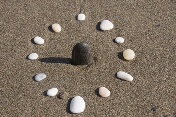 Fototapeta na wymiar Natural sun dial. Pebbles and sandy beach 