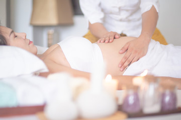 Obraz na płótnie Canvas Young beautiful pregnant woman having massage in spa salon.