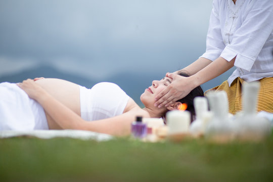 Pregnant women, spa massage, relax in a grass garden amidst beautiful nature