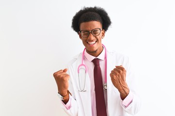 Young african american doctor man wearing pink stethoscope over isolated white background very happy and excited doing winner gesture with arms raised, smiling and screaming for success. 