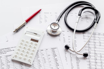 Health insurance concept. Stethoscope near financial documents and calculator on white background
