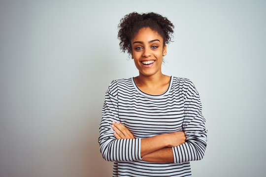 African american woman wearing navy striped t-shirt standing over isolated white background happy face smiling with crossed arms looking at the camera. Positive person.