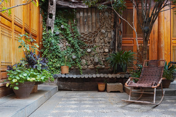 Fototapeta na wymiar Beautiful Naxi style courtyard at Lijaing with a rattan made rocking chair, China. 