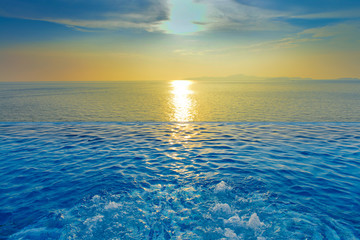 Fototapeta na wymiar Swimming Pool with sunset on the sea