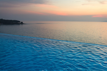 Swimming Pool with sunset on the sea