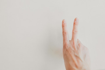 hand on a white background: two fingers. the concept of manifestation of emotions, gestures: peace