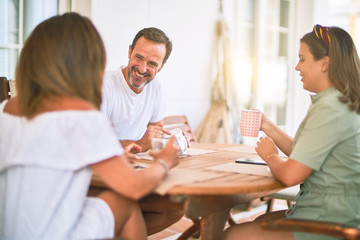 Beautiful family sitting on terrace drinking cup of coffee speaking and smiling