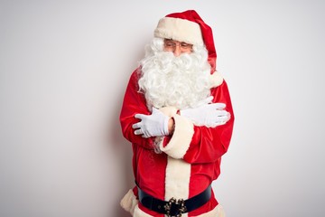 Middle age handsome man wearing Santa costume standing over isolated white background shaking and freezing for winter cold with sad and shock expression on face