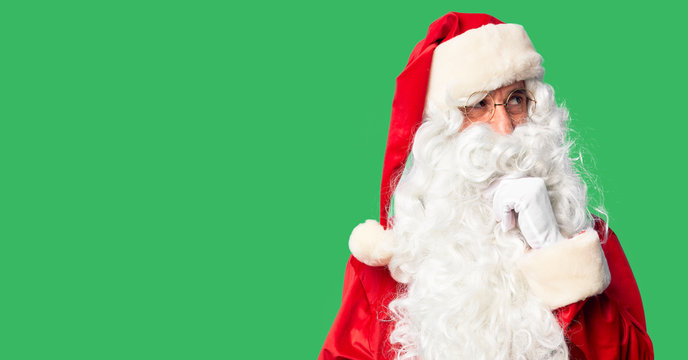 Middle age handsome man wearing Santa Claus costume and beard standing with hand on chin thinking about question, pensive expression. Smiling and thoughtful face. Doubt concept.