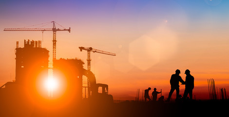Silhouette of Survey Engineer and construction team working at site over blurred  industry background with Light fair.Create from multiple reference images together