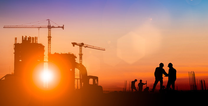 Silhouette of Survey Engineer and construction team working at site over blurred  industry background with Light fair.Create from multiple reference images together