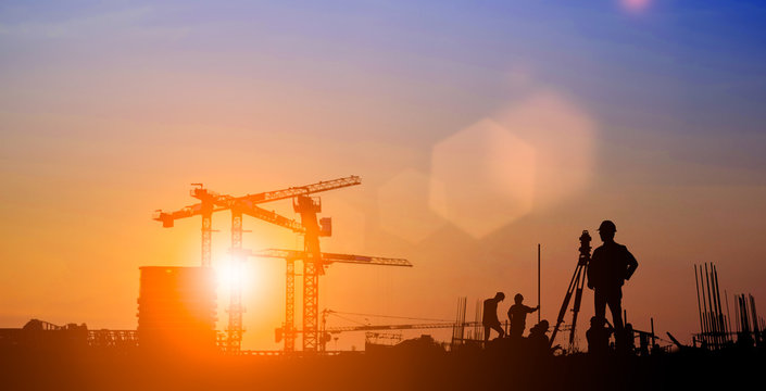 Silhouette of Survey Engineer and construction team working at site over blurred  industry background with Light fair.Create from multiple reference images together