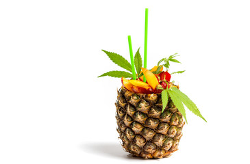Fruit salad and juice with marijuana in a pineapple shell isolated