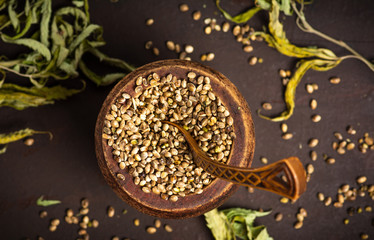 Cannabis seeds and marijuana leaves in a bowl on