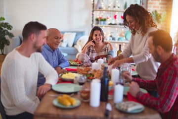 Beautiful family smiling happy and confident. Carving roasted turkey celebrating Christmas at home