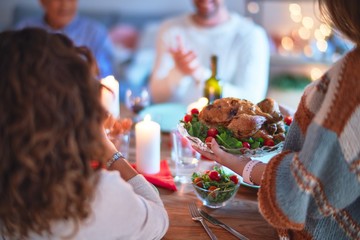 Beautiful family smiling happy and confident. Showing roasted turkey and applauding celebrating Thanksgiving Day at home