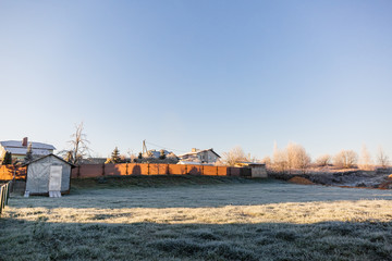 A plot of land with a lawn for the construction of a house or territory for grazing farm animals in frosty sunny morning