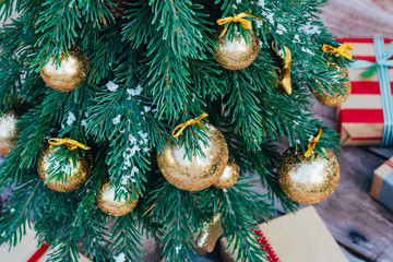Christmas background. Green fir tree with golden balls and gift boxes. - 303753435