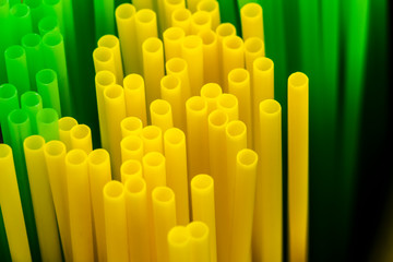 Many colored plastic tubes for drinks close-up.
