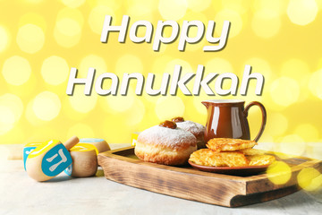 Dreidels, donuts and potato pancakes for Hanukkah on table