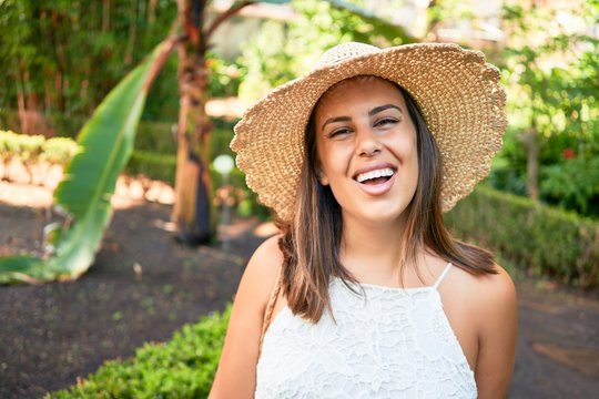 Young beatiful woman smiling happy and cheerful at green park on a sunny day of summer