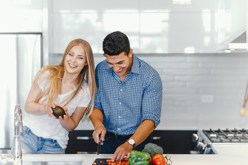Man in a kitchen. A handsome man with woman at home. Male and famale at home with vagatables....