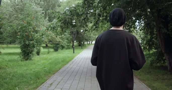 Rear view on man listens to music from cassette player outdoors
