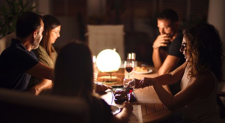 Beautiful family on dinner talking and smiling at terrace