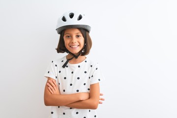 Beautiful child girl wearing security bike helmet standing over isolated white background happy face smiling with crossed arms looking at the camera. Positive person.