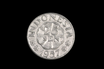 An old Indonesian, twenty five sen coin from 1957, shot close up in macro against a black background © Vitoria Holdings LLC